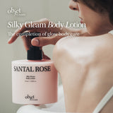 Silky Gleam Body Lotion bottle with a person applying lotion, featuring 'objet by kundal' branding.A model holding the OBJET BY KUNDAL Santal Rose Body Lotion, showcasing the "completion of glow body care" aesthetic.