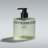 Body wash bottle with pump labeled 'Glowing Orchard' on a gray KUNDAL Objet Moist Gleam Body Wash in Glowing Orchard, 15.21 fl. oz. (450ml) premium bottle with Resveratrol C&E.background