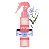 Pink hair mist serum bottle with floral design on a white background